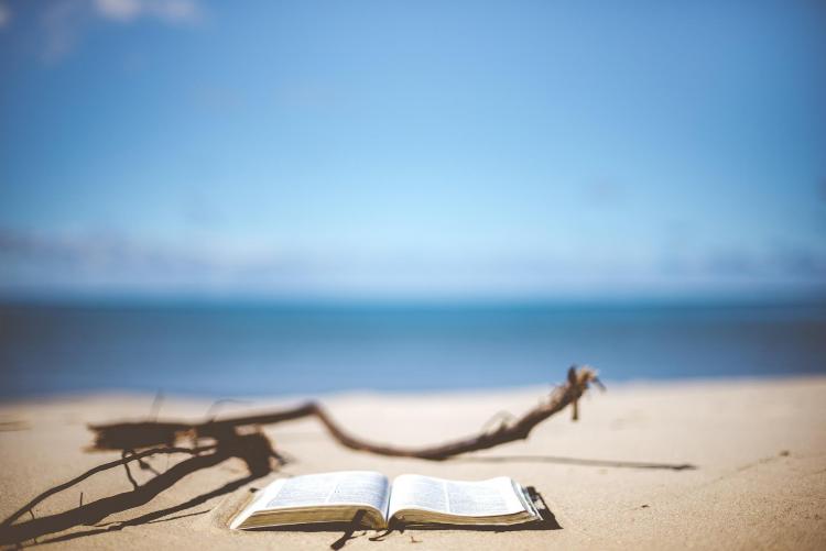 nell'immagine un libro aperto sulla sabbia, foto di Pexels da Pixabay