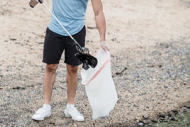 Un volontario raccoglie piccoli rifiuti - Foto di Lara Jameson da Pexels